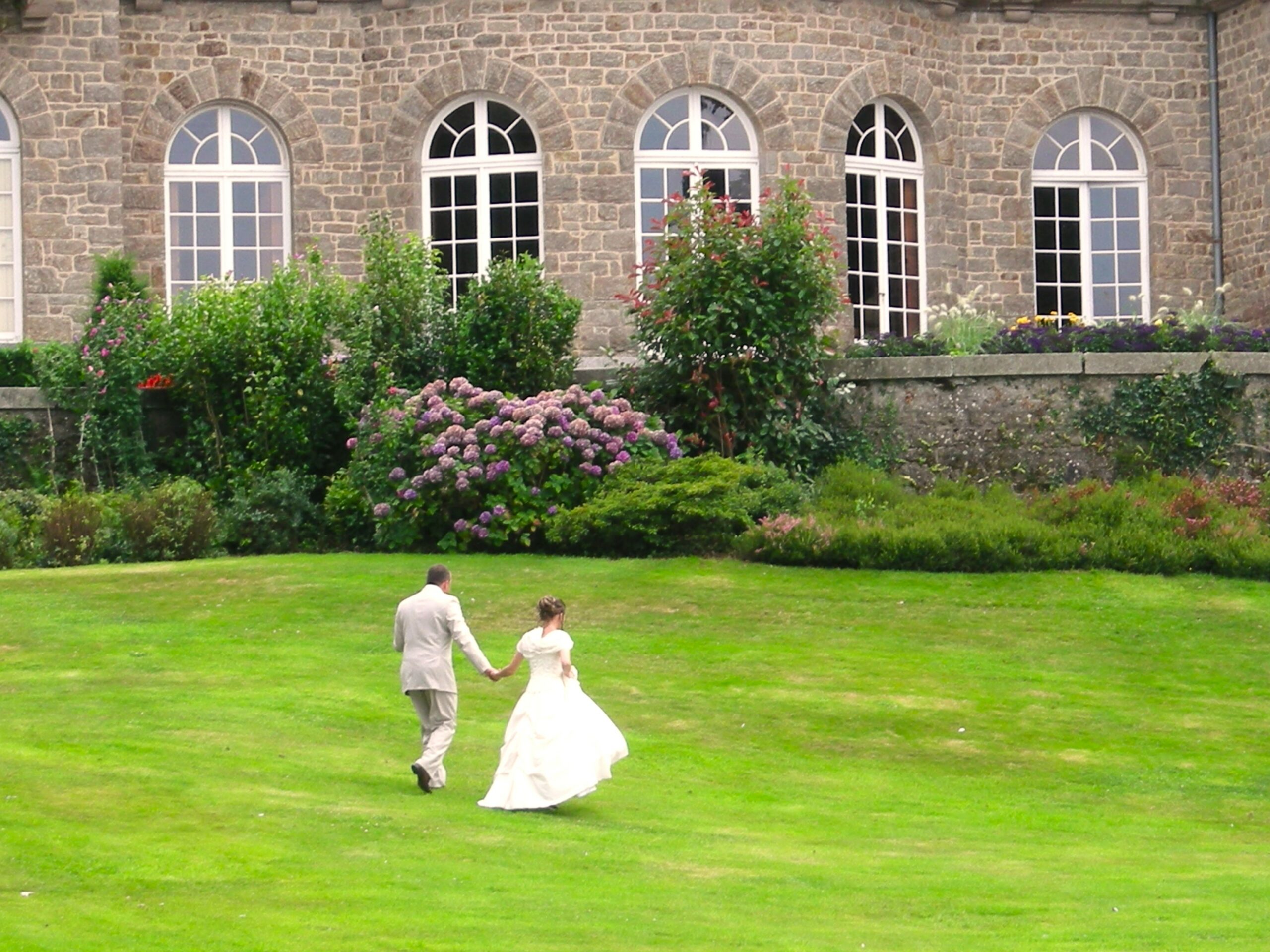 Les mariés dans l'herbe au pied du chateau