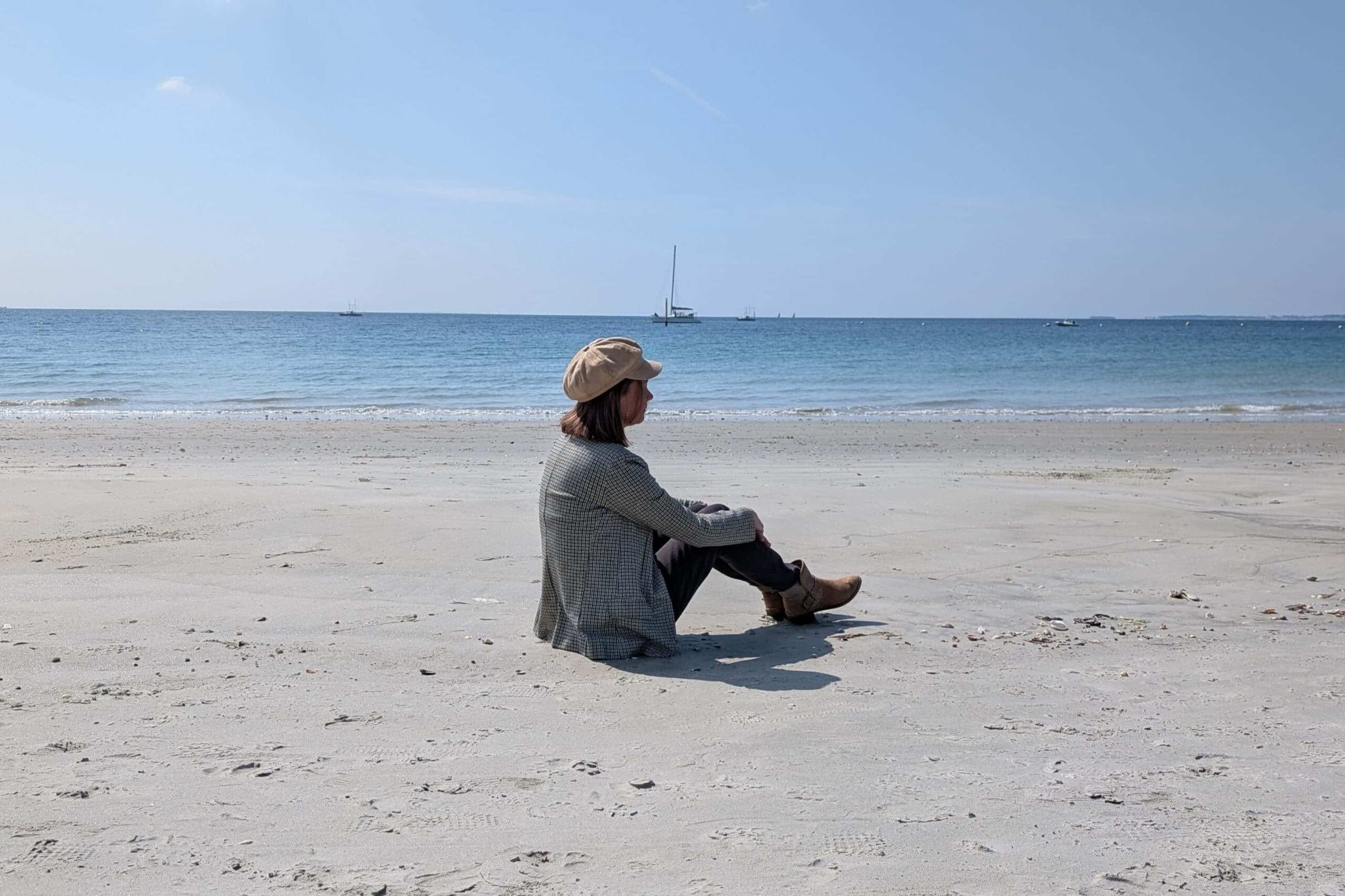 Sandrine, votre organisatrice, assise au bord de la mer réfléchi à son prochain mariage dans sa Bretagne natale
