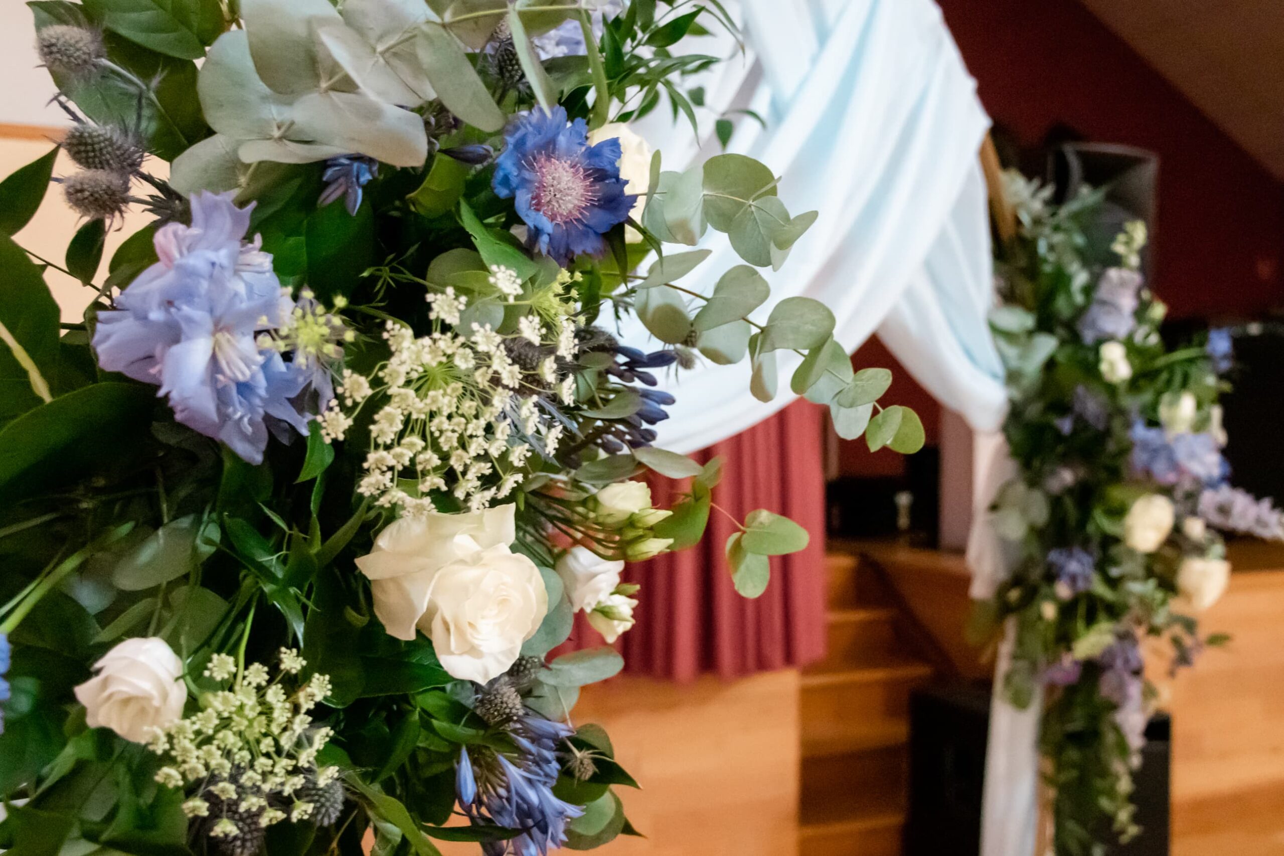 Une arche de cérémonie laïque de mariage ornée de fleurs blanches et bleues