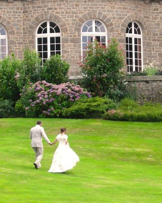 Les mariés dans l'herbe au pied du chateau