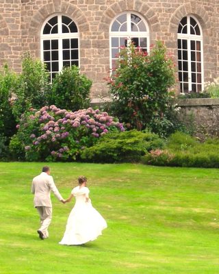 Les mariés dans l'herbe au pied d'un château dans le Morbihan